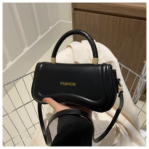 Close-up of black crossbody bag with yellow FASHION text and golden metal hardware