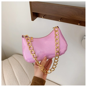 Detailed macro of pink sequin hobo bag featuring a chunky gold metal chain strap