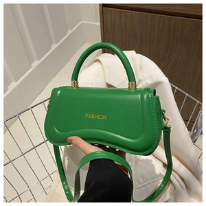 Detail of green PU leather handbag with yellow FASHION text and gold metal hardware