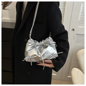 Silver metallic pleated bucket bag with bow accents and chain shoulder strap