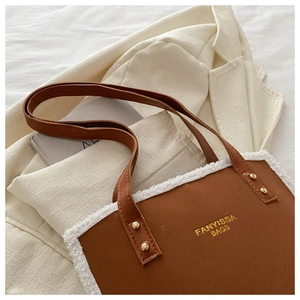 Close-up of brown faux leather bag with white plush trim and golden FANYISSA brand logo