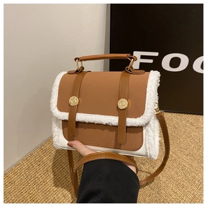 Detail of plush shearling and brown leather patchwork on elegant square crossbody handbag