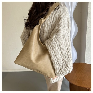 Detailed side view of khaki soft leather tote bag showing large capacity and knot strap