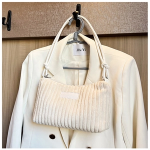 Minimalist beige corduroy shoulder bag with vertical stripe texture and knotted strap detail