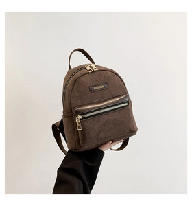 Close-up of retro brown corduroy mini backpack featuring golden zippers and fashion label
