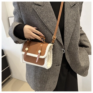 Detail view of retro square bag with brown leather and off-white faux shearling contrast