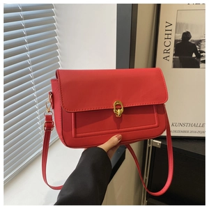 Vue détaillée du sac à rabat en cuir rouge avec boucle dorée et surpiqûres décoratives