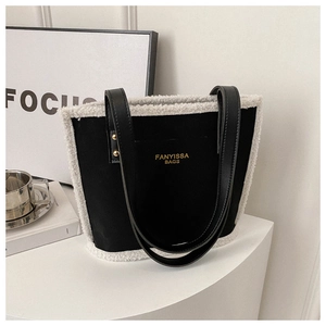 Close-up of black shoulder bag with white faux fur trim and gold Fanyissa Bags logo
