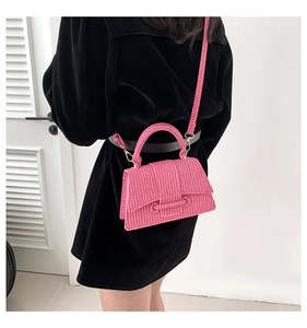 Detail of pink woven texture crossbody bag with sturdy handle and gold-tone hardware