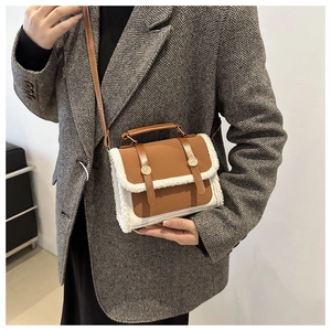 Detail of vintage crossbody bag with brown leather and white sherpa fur trim and gold buckles