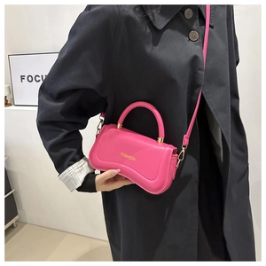 Detail of bright pink mini bag featuring gold hardware and removable shoulder strap