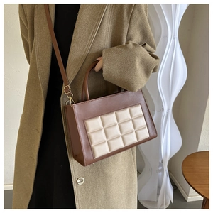 Detail of checkered quilted panel on a contrast leather crossbody bag for women