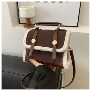 Close-up of brown vintage crossbody bag featuring white faux fur trim and gold hardware