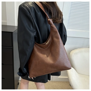 Detailed view of the brown lychee textured shoulder bag with stylish knotted strap detail