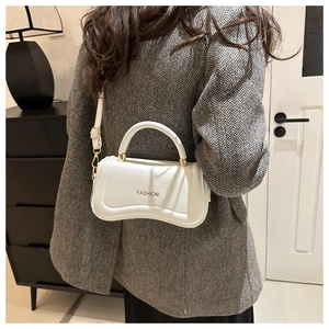 Detail view of white PU leather crossbody bag with wavy bottom and gold fashion buckle