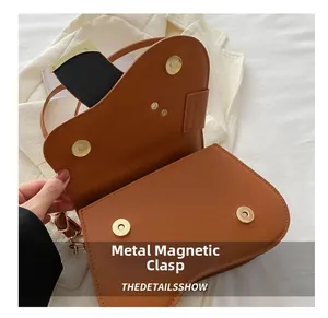Detail view of the brown leather saddle bag interior featuring four gold magnetic buckles