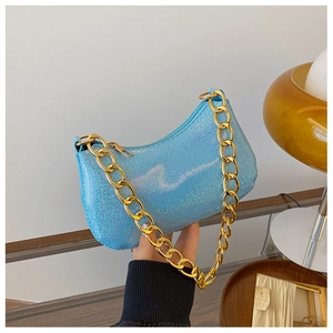 Detail of light blue sequin underarm bag with a chunky gold chain strap and moon shape