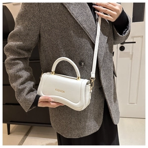 Detail of white PU leather crossbody bag with golden FASHION logo and modern stitching