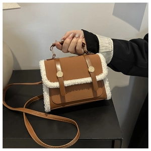 Brown faux leather handbag with white faux shearling trim and golden buckle details