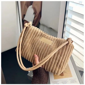 Detail of beige corduroy tote bag showing ribbed texture and knotted shoulder strap