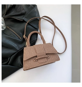 Detailed close-up of brown woven texture bag next to a stylish black leather jacket