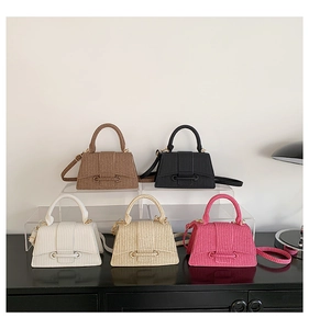 Minimalist textured handbags in five colors displayed on transparent acrylic stands