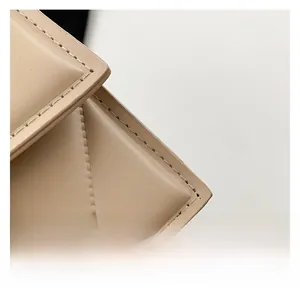 Close-up of quilted diamond pattern on beige faux leather bag with high-quality stitching