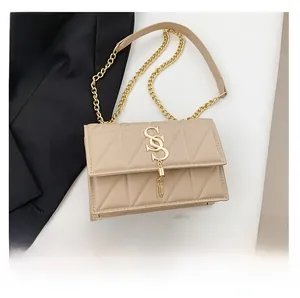 Detail view of beige quilted square bag with gold hardware and phone size comparison