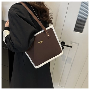 Detail of dark brown faux leather tote with white plush trim and golden brand logo