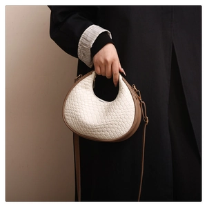 Retro woven leather half-moon shoulder bag with brown trim and adjustable strap