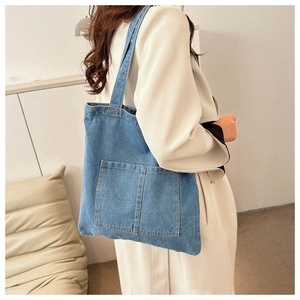 Classic blue denim tote bag with visible stitching and practical front pockets