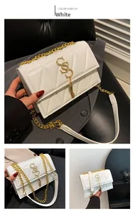 Close-up of white quilted leather bag with gold S-logo and chain strap detail
