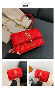 Detail of red quilted nylon tote bag featuring gold S-buckle and elegant metallic fringe