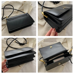 Detailansichten der schwarzen Umhängetasche mit goldener Hardware und zwei Innenfächern