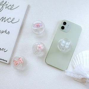 Glittery cell phone grip set with pink bow and candy charms on a mint green phone