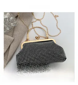 Macro view of black evening clutch with glittering rhinestones and gold ring handle
