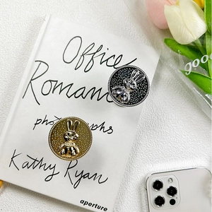 Gold and silver rabbit phone grips on a book featuring a chic minimalist lifestyle design