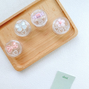 Macro shot of glittery resin bow and candy phone grips on a wooden tray