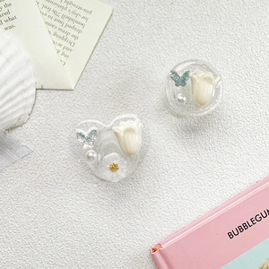 Détail macro des supports de téléphone en résine à paillettes avec tulipes et papillons
