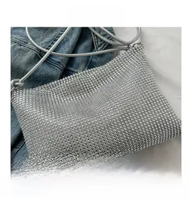 Detail der glänzenden silbernen Strasssteine und des Metallriemens der Abendtasche