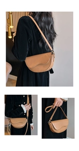 Détail d'un sac besace en cuir marron avec boucle dorée et bandoulière réglable