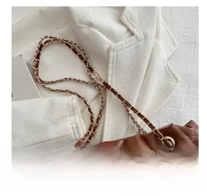 Close-up of brown quilted faux leather tote with chain link shoulder strap detail