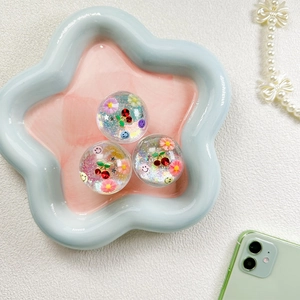 Détail de supports de téléphone avec cerise, smiley et paillettes scintillantes