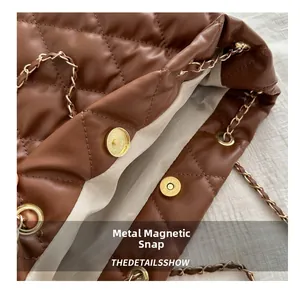 Detailed close-up of brown quilted bucket bag with magnetic clasp and chain strap
