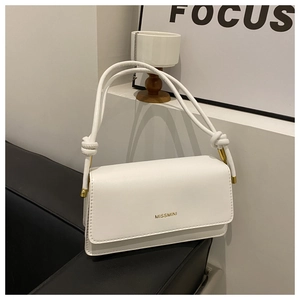 Detailansicht der weißen Leder-Umhängetasche mit goldenem Logo und Seilträgern