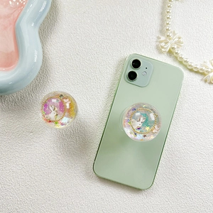 Glitter bunny crystal ball phone grip with star sequins on a light green smartphone