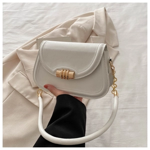 Close-up of white saddle bag with golden metal hardware and elegant chain detail