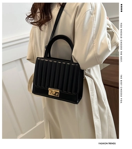 Détail du sac bandoulière noir plissé avec fermoir en métal doré et poignée supérieure