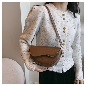 Sac bandoulière marron vintage avec rabat ondulé et détails dorés sur un mannequin