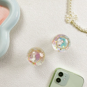 Close-up of glittery liquid sand phone grips featuring cute rabbit and star sequins